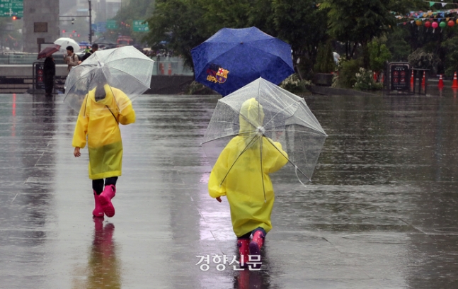 지난 5월5일 서울 광화문광장을 찾은 어린이들이 우산을 쓰고 이동하고 있다. 서성일 선임기자