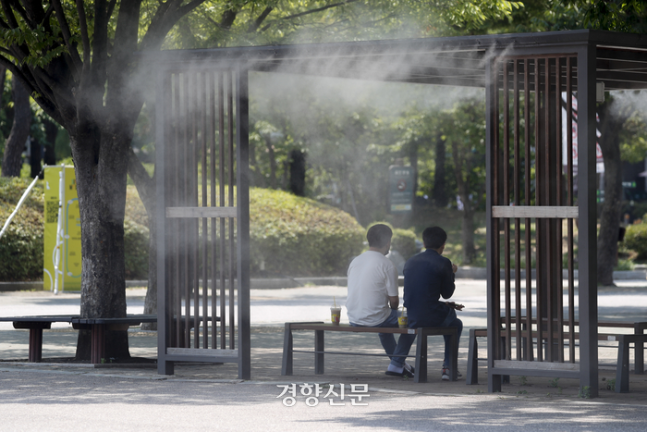 금요일인 28일 낮 최고기온이 30도 이상 오르는 무더위가 예상된다. 사진은 최근 서울 여의도 공원에서 더위를 식히기 위한 쿨링 포그 근처 의자에 앉아있는 사람들의 모습이다. 경향신문 자료사진