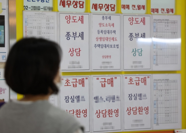 서울의 한 부동산 중개업소에서 시민이 종부세 상담 관련 안내판을 보고 있다. 연합뉴스