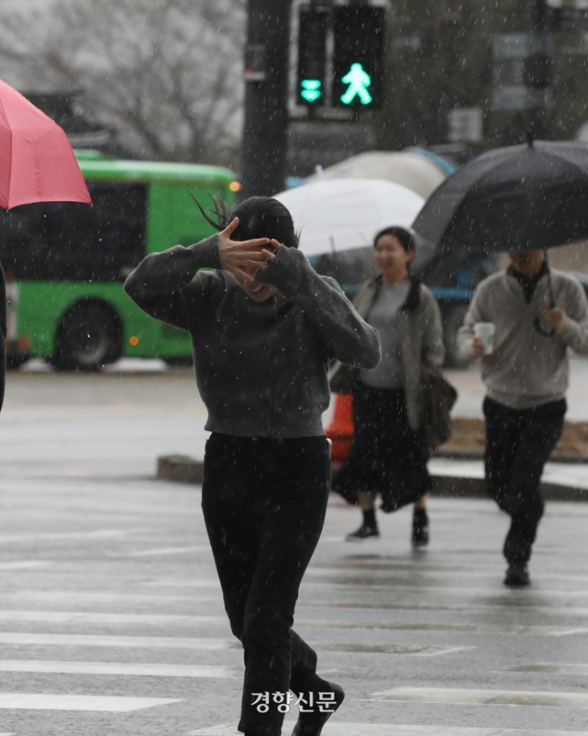 소나기가 내리는 서울 종로구를 지나던 시민이 손으로 비를 막고 있다. 정효진 기자