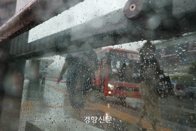 전국적으로 장맛비가 내린 지난 2일 서울 광화문 광장 근처 버스 정류장에 시민이 우산을 쓰고 걸어가고 있다. 정효진 기자