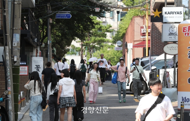 지난달 26일 시민들이 서울 마포구 홍대 거리 피규어 가게들이 늘어선 골목길을 지나고 있다. 정지윤 선임기자