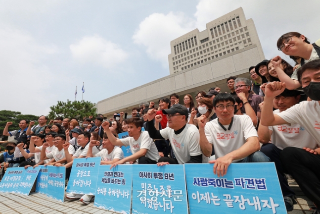 2015년 집단 해고로 분쟁을 겪었던 차헌호 민주노총 금속노조 아사히글라스비정규직지회장과 조합원들이 11일 서울 서초구 대법원 앞에서 승소 판결 기자회견을 마친 후 연대단체 활동가들과 함께 기념 촬영을 하고 있다. 