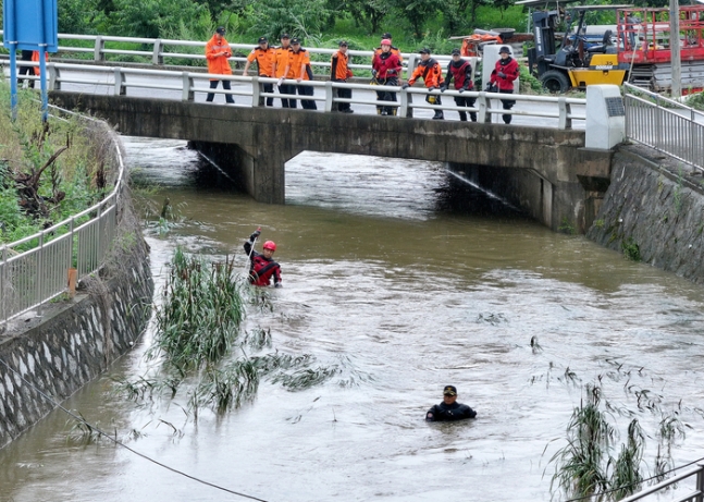 지난 9일 오후 경북 경산시 진량읍 평사리 소하천에서 소방구조대가 폭우에 실종된 여성을 수색하고 있다. 연합뉴스