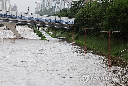 많은 비가 내린 18일 오전 경기도 성남시 탄천 주변 산책로가 물에 잠겨 있다. 연합뉴스