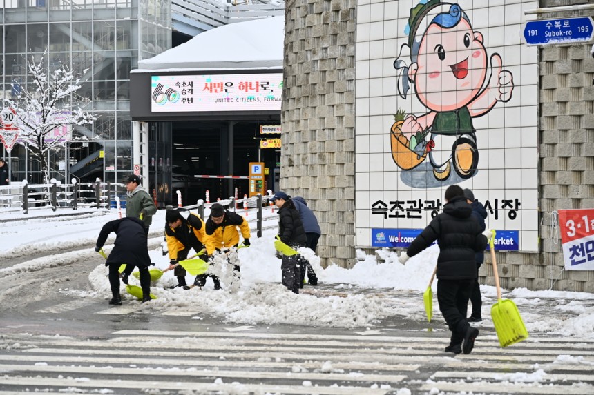 在第三名中,索科市政廳的員工正在索克喬旅遊漁業市場前進行降雪。由Sokcho City提供