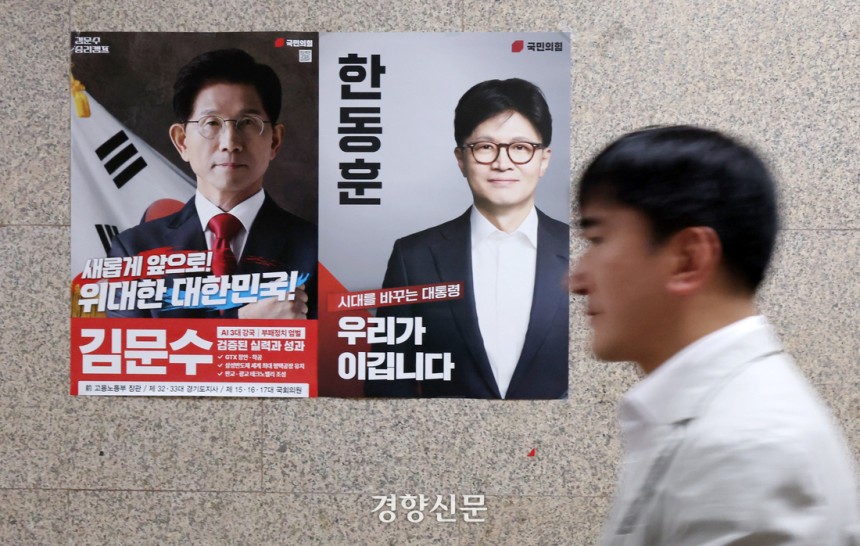 국민의힘 당직자가 30일 국회 국민의힘 사무실 앞에 부착된 김문수, 한동훈 대선 경선 후보 포스터 앞을 지나가고 있다. 박민규 선임기자