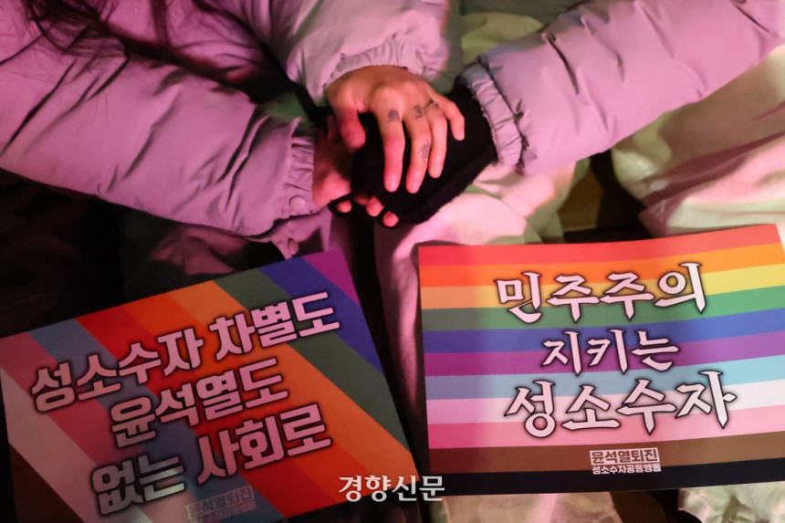 지난해 12월 25일 서울 중구 국가인권위원회 인근에서 열린‘윤석열 퇴진하고 평등세상으로’집회에서 참가자들이 손을 잡고 있다.한수빈 기자