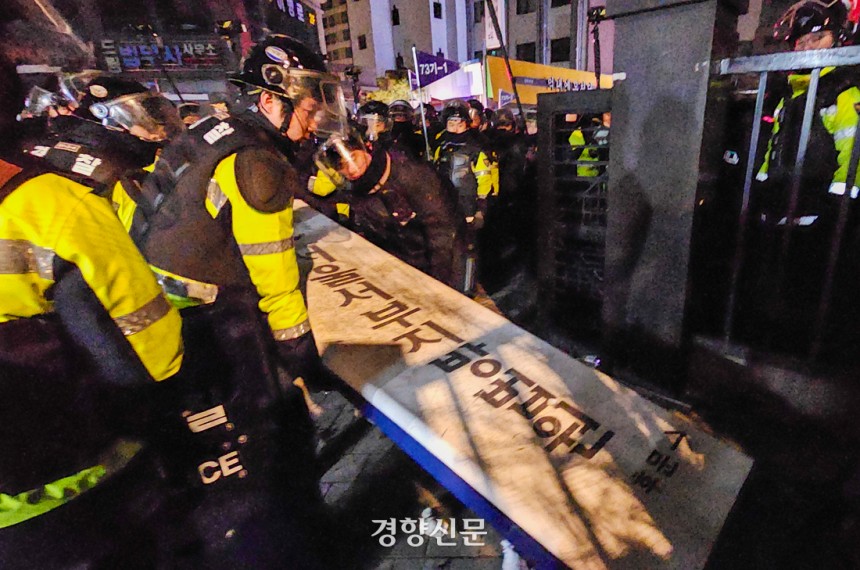 경찰이 지난 1월19일 서울 마포구 서울서부지법 후문에서 윤석열 전 대통령의 구속에 항의하며 시위대가 넘어뜨린 법원 간판을 다시 세우고 있다.이준헌 기자