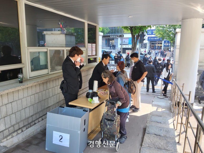 서울중앙지법 관계자들이 12일 오전 서울 서초구 서울중앙지법 동문 출입구에서 출입자들의 소지품을 검사하고 있다.김태욱 기자