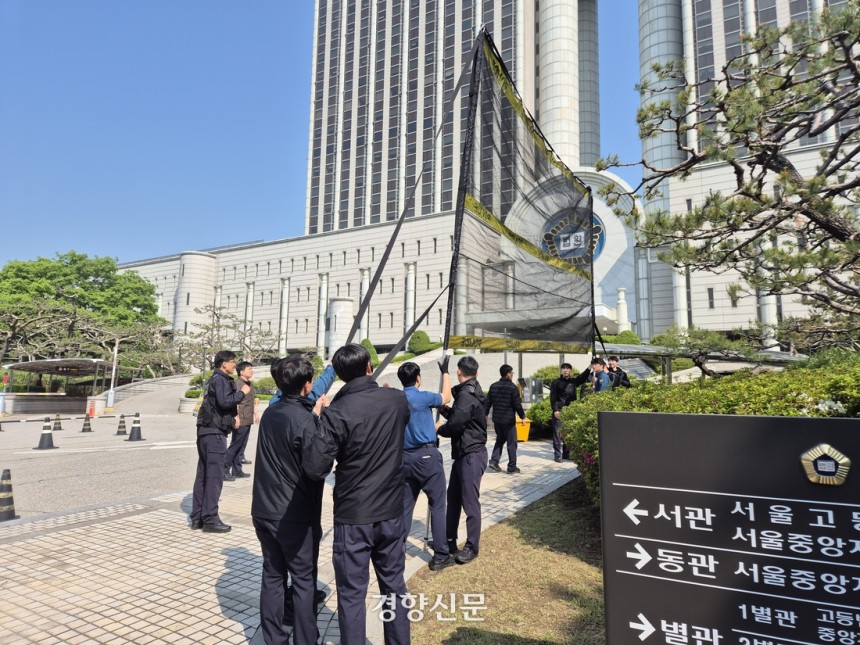 경찰 관계자들이 12일 오전 서울 서초구 법원 청사 앞에서 투척물 방지용 그물망을 펴 보이고 있다.김태욱 기자