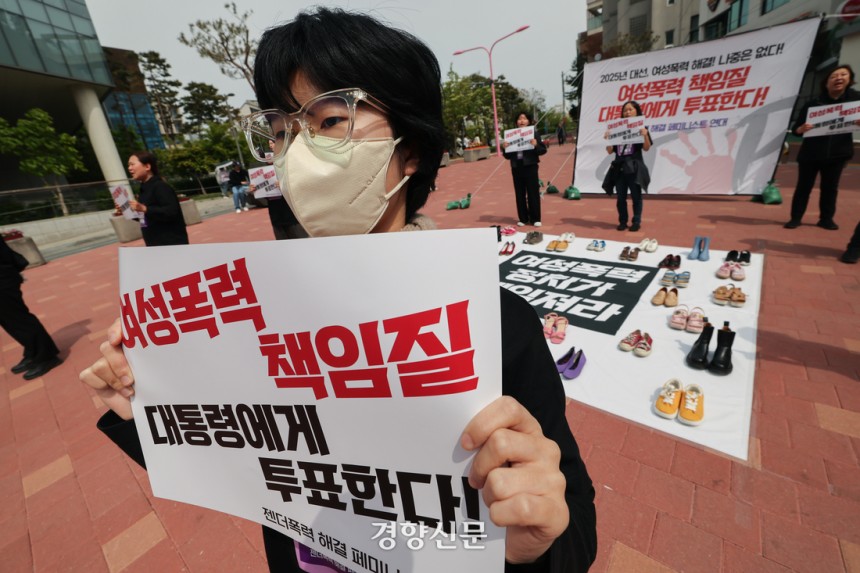 서울여성회 페미니스트 대학생연합동아리 회원들이 지난달 27일 서울 마포구 홍대입구역 앞에서 열린 ‘2025 대선, 여성폭력 해결! 나중은 없다!’ 캠페인에서 여성폭력 희생자들을 상징하는 신발을 놓고  다이-인(Die