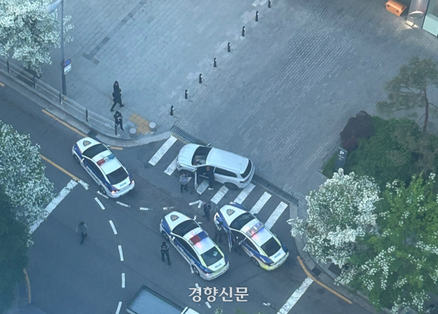 서울 마포경찰서 경찰관들이 지난 12일 오전 6시쯤 마포구 상암동 한 언론사 앞에서 시민을 차로 쳐 특수폭행 혐의를 받는 50대 남성 A씨를 현행범으로 체포하고 있다. 김모씨 제공