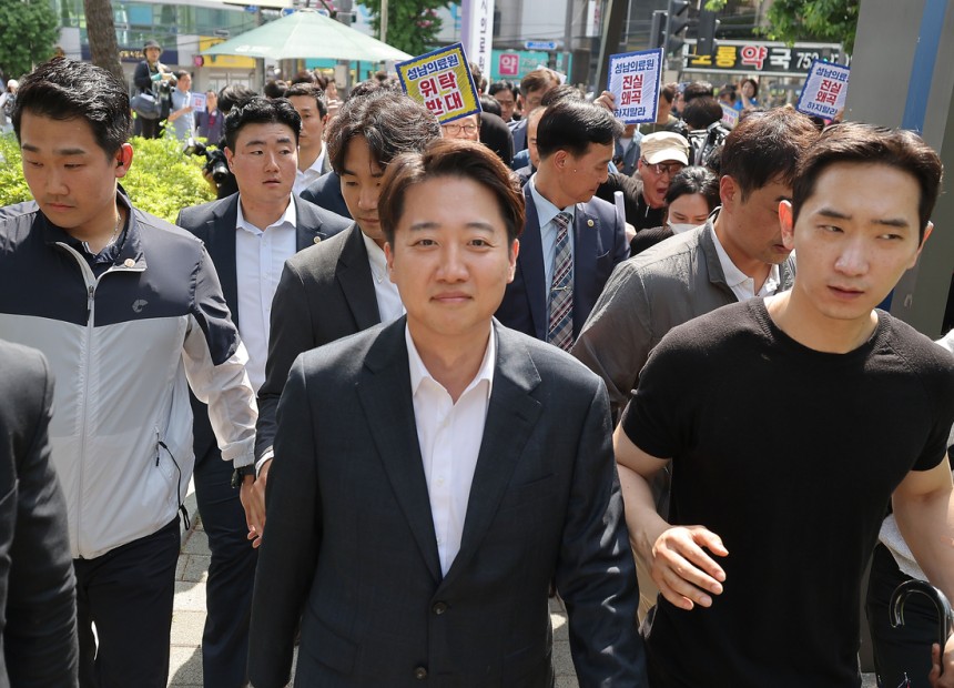 개혁신당 이준석 대선 후보가 21일 경기 성남의료원에 도착, 시민단체 회원들의 항의를 받으며 들어서고 있다. 연합뉴스