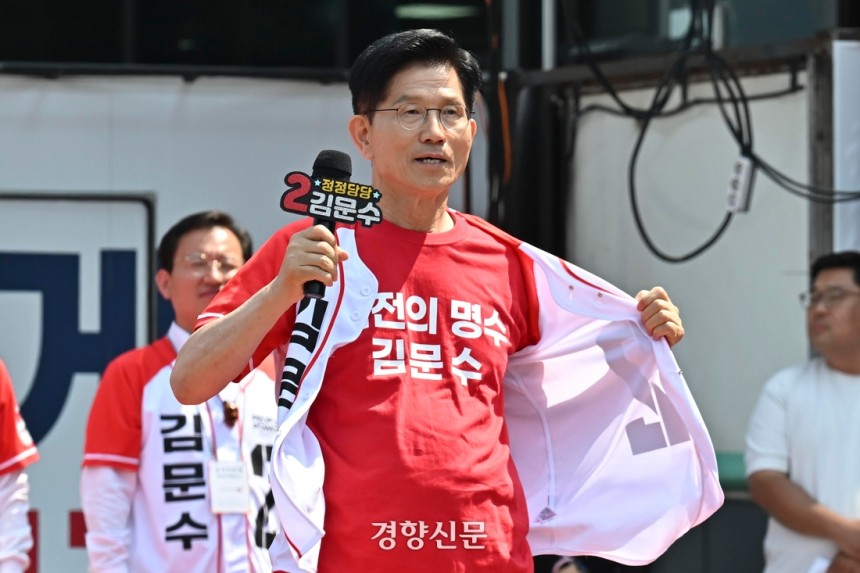 김문수 국민의힘 대선 후보가 25일 충남 보령시 대천역 광장에서 열린 유세에서 ‘나는 방탄복을 입지 않았다’며 선거복 단추를 열고 있다.  한수빈 기자
