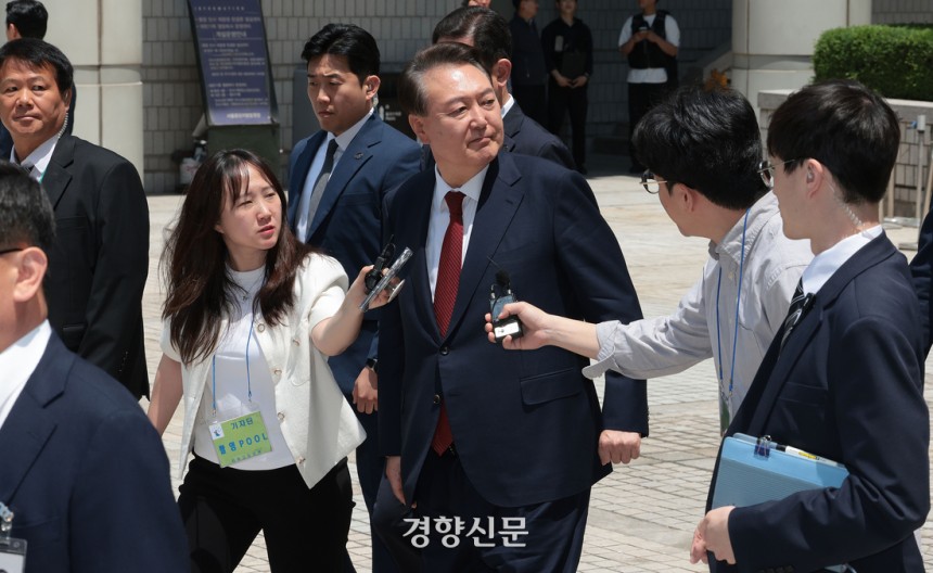 윤석열 전 대통령이 26일 서울 서초구 서울중앙지방법원에서 열린 내란 우두머리 혐의ㆍ직권남용 권리행사 방해 혐의 사건 5차 오전 공판을 마친 뒤 지지자들을 바라보며 차량으로 향하고 있다. 사진공동취재단