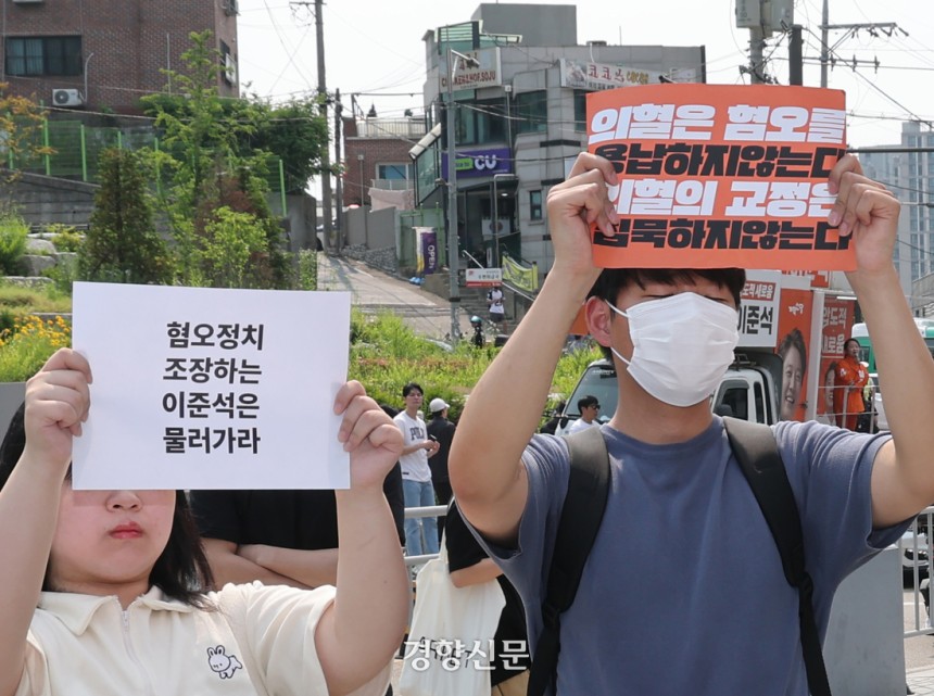 이준석 개혁신당 대선 후보가 지난달 30일 서울 동작구 중앙대학교에서 유세 중인 가운데 일부 학생들이 최근 이 후보의 TV토론 여성 신체 관련 발언을 규탄하며 팻말을 들고 있다.  정지윤 선임기자