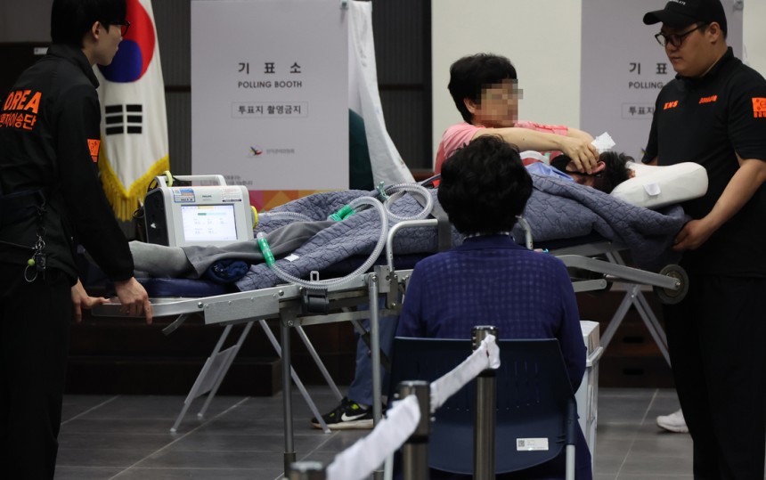 3일 서울 용산구 중부기술교육원에 마련된 한남동 제3투표소에서 한 환자가 보호자와 구급대원의 도움을 받아 투표에 참여하고 있다. 연합뉴스