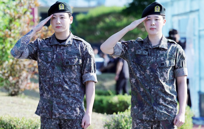 육군 현역 복무를 마친 그룹 BTS의 지민과 정국이 11일 오전 경기도 연천군 연천공설운동장에서 거수경례로 전역을 알리고 있다. 연합뉴스
