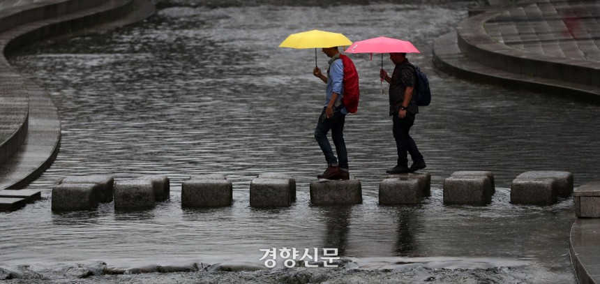 비가 내리는 서울 종로구 청계천 광통교 부근을 지나는 시민들이 우산을 쓰고 징검다리를 건너고 있다. 김창길 기자