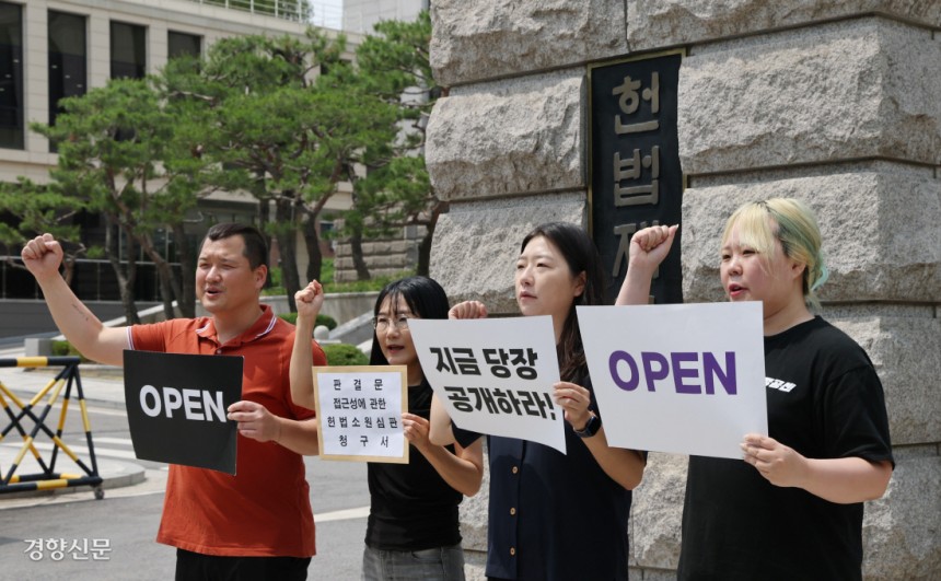 김정희원 미국 애리조나주립대 교수(왼쪽에서 두번째)와 투명사회를 위한 정보공개센터 활동가들이 지난 13일 서울 종로구 헌법재판소 앞에서 판결문 접근성에 관한 헌법소원 청구에 앞서 구호를 외치고 있다. 왼쪽부터 강성국