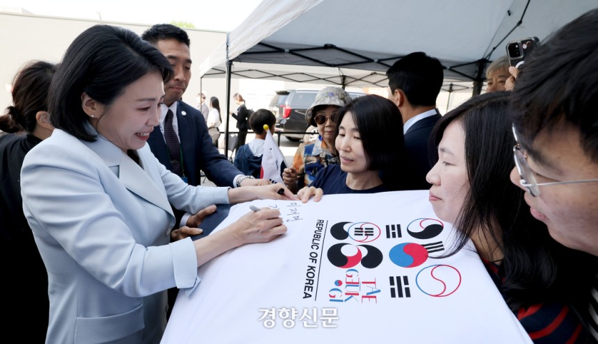 이재명 대통령 부인 김혜경 여사가 17일(현지시간) 캐나다 앨버타주 캘거리 한인회관을 방문해 캐나다 서부 동포사회와의 대화를 나누기 전 동포들과 인사를 나누며 티셔츠에 싸인을 하고 있다. 김창길 기자