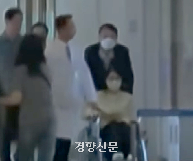 우울증 등으로 입원했던 김건희 여사가 27일 서울 아산병원에서 퇴원하고 있다. 윤석열 전 대통령이 김 여사의 휠체어를 밀고 있다. YTN 캡처