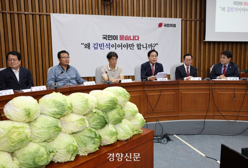 송언석 국민의힘 원내대표(오른쪽에서 세번째)가 30일 국회에서 열린 김민석 국무총리 후보자 ‘국민청문회’에서 배추를 쌓아놓고 발언하고 있다.  국민의힘은 김 후보자의 배추 농사 투자가 석연치 않다고 주장하고 있다. 