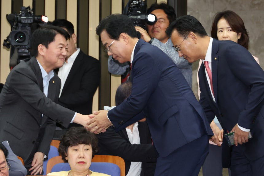 지난달 30일 송언석 국민의힘 비상대책위원장 겸 원내대표(가운데)가 국회에서 열린 의원총회에 참석해 안철수 의원과 악수하고 있다. 연합뉴스