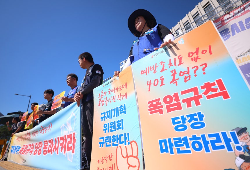 민주노총 조합원들이 11일 서울 종로구 정부서울청사 앞에서 정부 규제개혁위원회(규개위)의 폭염 규칙 통과 촉구 기자회견을 하고 있다. 연합뉴스