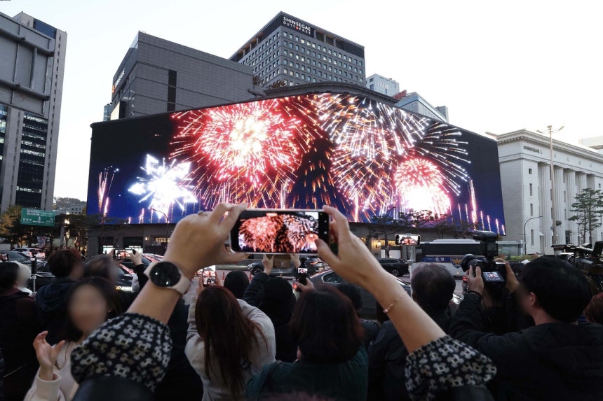 신세계백화점 소공동 본점의 초대형 미디어아트 크리스마스 영상을 관람객이 찍고 있다. 신세계백화점 제공