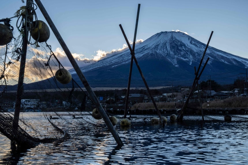 지난 5일 일본 야마나시현 야마나카호수에 세워져 있는 어구들 너머로 후지산의 모습이 보인다.AFP연합뉴스