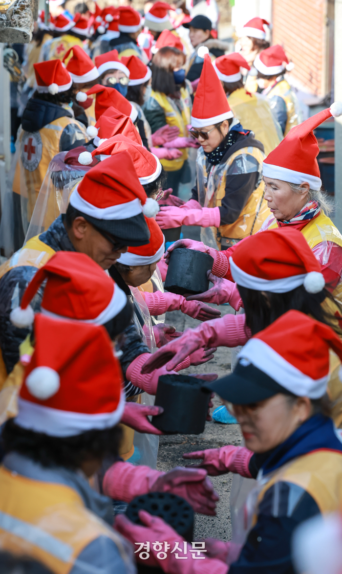대한적십자사 봉사원들과 고려아연 임직원들이 지난 2일 서울 노원구 상계동 일대에서 취약계층에게 전달할 연탄을 나르고 있다.성동훈 기자