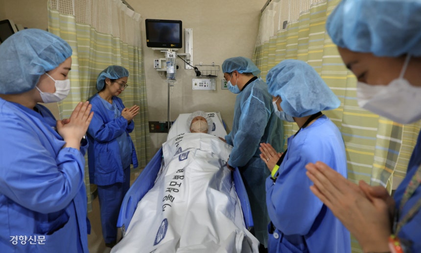 가톨릭대학교 서울성모병원 영성부원장 신희준 신부(오른쪽에서 세번째)가 지난 11일 수술 전 대기실에서 간호사들과 함께 수술을 앞둔 환자를 위해 기도하고 있다.서성일 선임기자