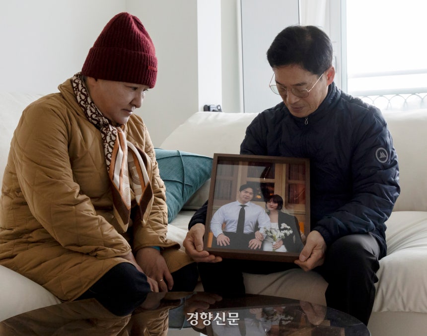 12·29 무안공항 제주항공 참사로 아들(노상훈)과 며느리(윤휘수)를 잃은 노현수·나명례 씨가 지난 23일 광주에 위치한 아들 내외의 집에서 인터뷰하기 전 결혼 사진을 보여주고 있다.광주 l 문재원 기자