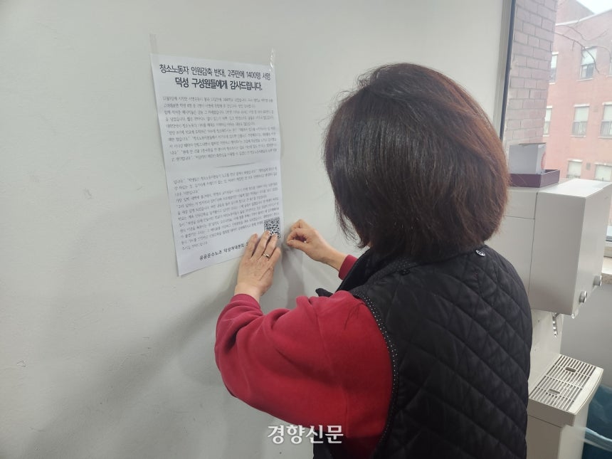 지난 12월 23일 덕성여대 청소노동자가‘인원 감축 반대’서명에 참여해준 학생들에게 감사하다는 내용의 노조 인사말을 학교 건물 벽에 붙이고 있다.이혜리 기자