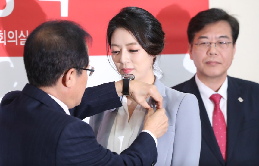 홍준표 전 대구시장이 자유한국당(현 국민의힘) 대표를 지내던 2018년 자유한국당에 입당한 배현진 당시 MBC 아나운서(현 국민의힘 의원)에게 태극기 배지를 달아주고 있다. 경향신