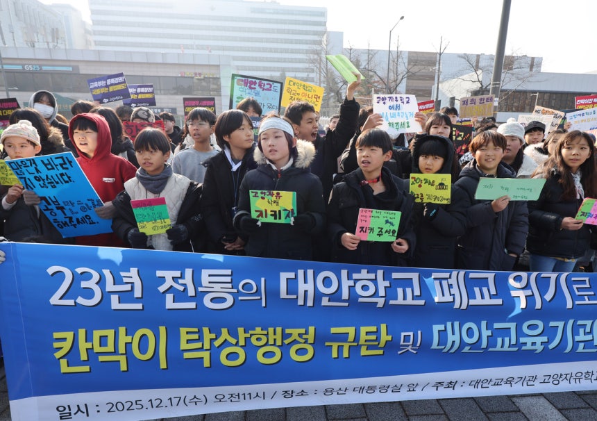 지난해 12월 17일 서울 용산 대통령실 앞에서 열린 고양자유학교 사태 해결 촉구 기자회견에 참석한 고양자유학교 학생,학부모들이 손팻말을 들고 있다.연합뉴스