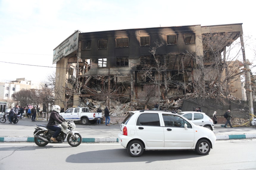 차량들이 지난 21일(현지시간) 이란 테헤란에서 최근 시위 과정에서 파괴된 세무서 건물 앞을 지나가고 있다. 신화연합뉴스