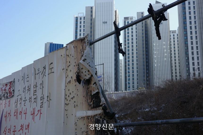 지난달 29일 마포구 아현동의 한 도롯가에 그을린 흔적이 있는 가설울타리 너머로 재건축으로 지어진 고층 아파트가 보인다. 우혜림 기자