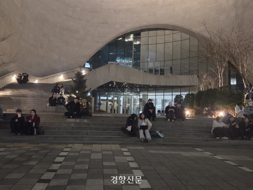 21일 서울 광화문에서 열린 방탄소년단의 공연을 멀리서나마 보기 위해 온 아미와 시민들이 인근 건물 앞 계단에 앉아 생중계로 공연을 보고 있다. 우혜림 기자