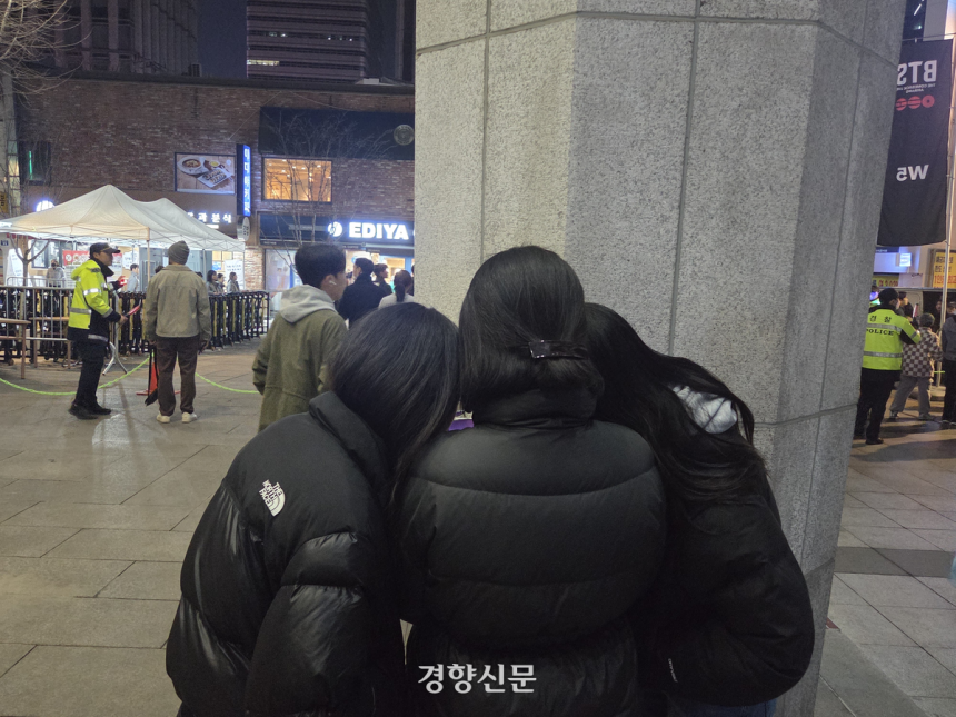 21일 서울 광화문에서 열린 방탄소년단의 공연을 멀리서나마 보기 위해 온 이들이 인근 건물 앞에서 생중계로 공연을 보고 있다. 우혜림 기자