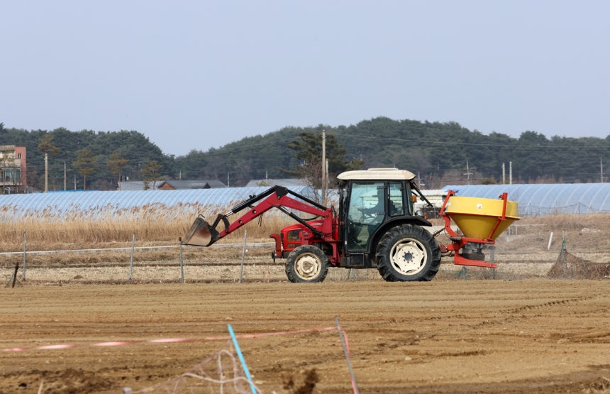 봄기운이 완연한 지난 2월23일 강원 강릉시 경포동에서 농민이 밭에 비료를 주고 밭을 가는 농사 준비로 바쁜 모습이다. 연합뉴스
