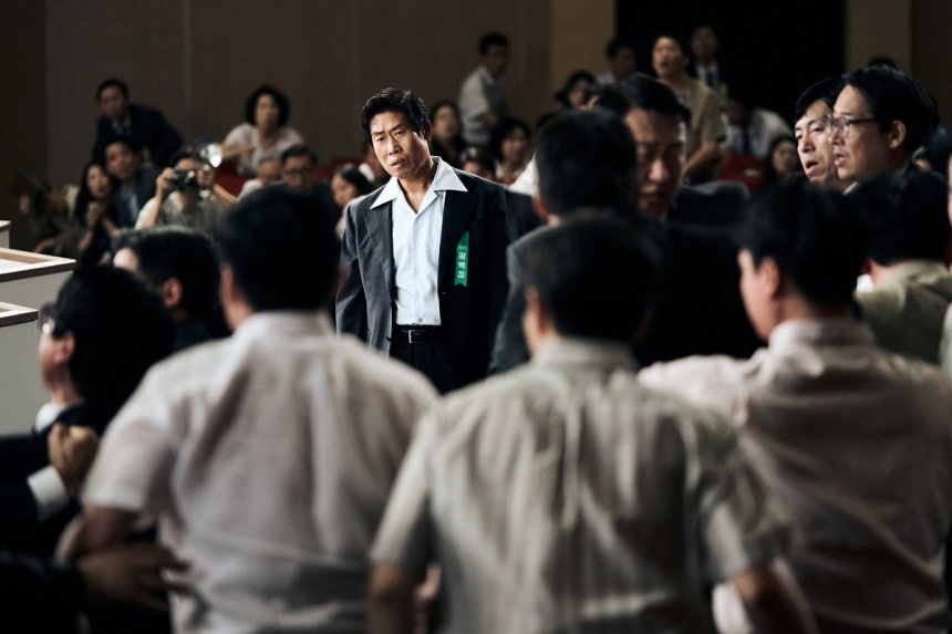 영화 <암살자(들)>의 형사‘철구’(유해진)가 1974년 8월15일 서울 장충동 국립극장에서 열린 광복절 경축식에서 경비를 서고 있다.하이브미디어코프 제공