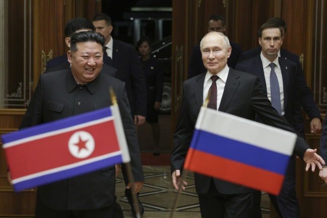 2024년 6월19일 정상회담을 열어‘포괄적인 전략적 동반자 관계에 관한 조약’을 체결한 김정은 북한 국무위원장(왼쪽)이 블라디미르 푸틴 러시아 대통령과 양국 국기를 배경으로 환하게 웃고 있다.AP 연합뉴스