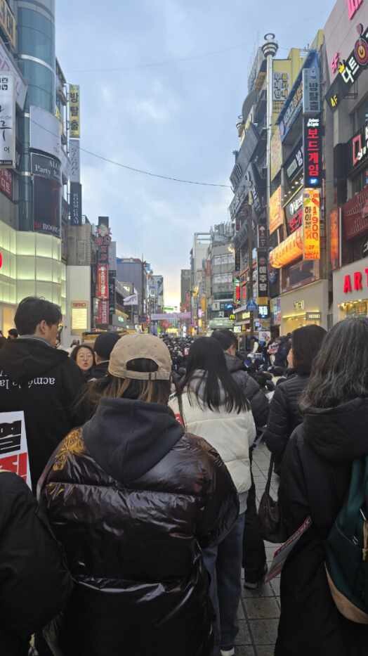 부산 시민 주라사(왼쪽 검은 패딩 입은 이)가 2024년 12월 윤석열 퇴진 촉구 집회에 앉아 있다.본인 제공