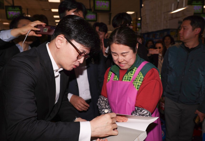 제21대 대통령 선거 출마를 선언한 국민의힘 한동훈 전 대표가 2025년 4월10일 서울 동작구 노량진 수산시장에서 자신의 저서에 사인하고 있다.연합뉴스