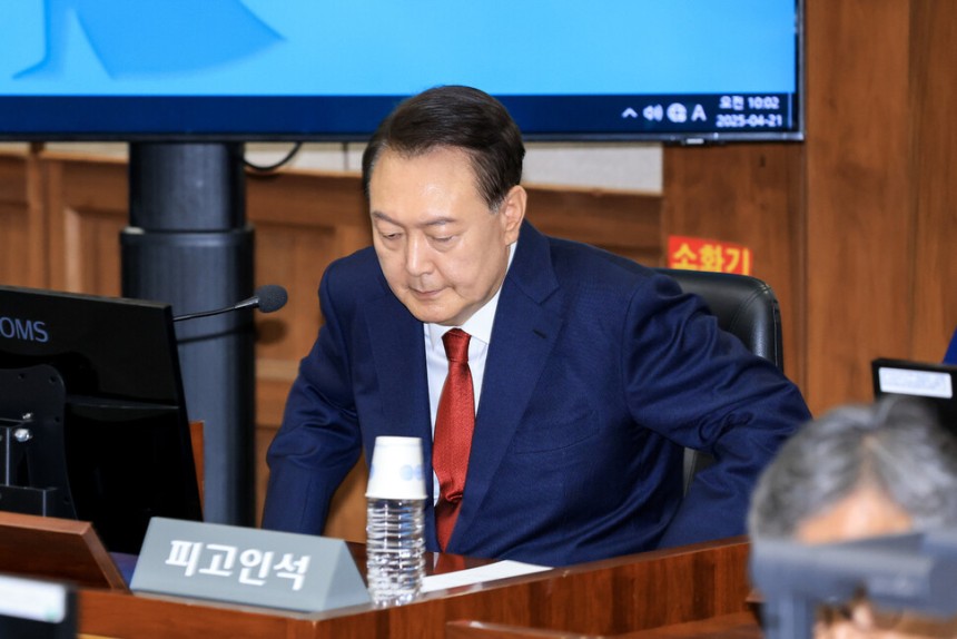 ‘내란 우두머리’피고인 윤석열이 2025년 4월21일 서울 서초구 서울중앙지법에서 열린 재판에 출석해 피고인석에 앉고 있다.사진공동취재단
