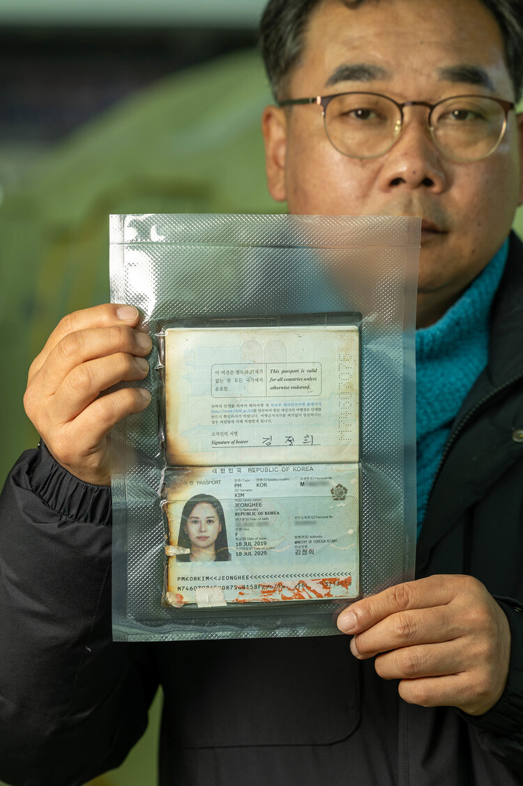 무안 제주항공참사로 아내와 두 아이를 잃은 김영헌씨가 2025년 12월15일 전남 무안 공항에서 고인의 불타다 남은 여권을 들어 보이고 있다.무안(전남)=김진수 선임 기자 