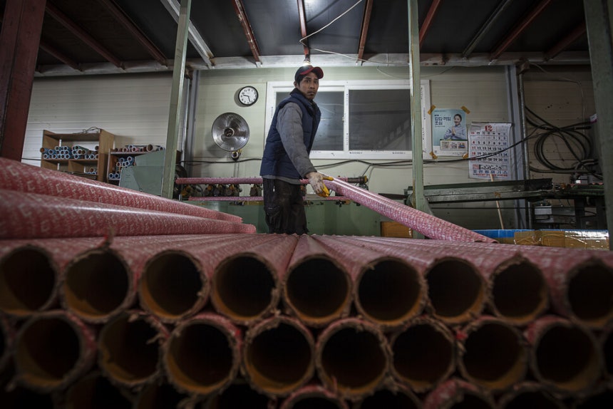 접경지의 공장에서 인도네시아 출신 이주노동자가 작업대에서 지관을 옮기고 있다.(2016년 12월)